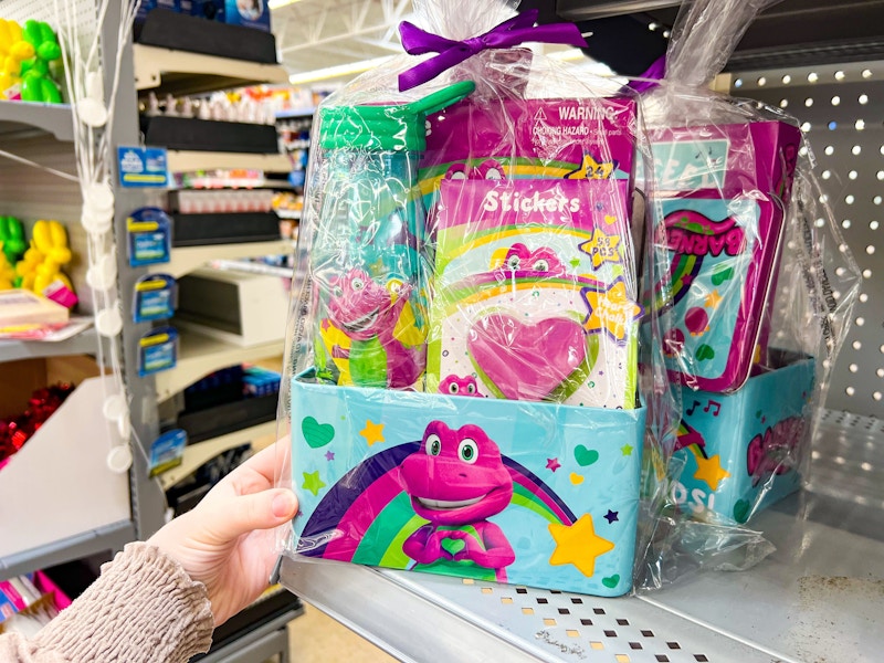 hand holing barney tin gift set on walmart shelf