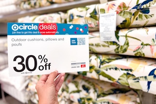 hand holding the 30% promotion sign in front of outdoor cushions
