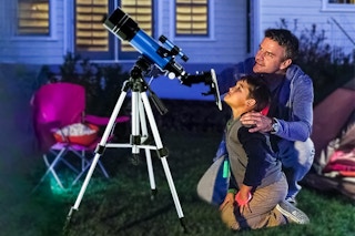 Lifestyle image of a Telmu Telescope being used outdoors at night by a father and his son