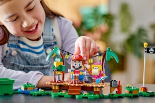 Girl playing with the LEGO Super Mario Dixie Kong’s Jungle Jam Expansion Set.