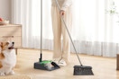 a person sweeping with a broom and dustpan 