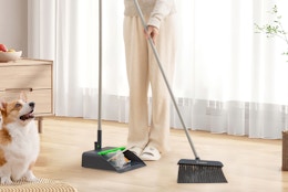a person sweeping with a broom and dustpan 