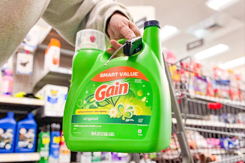 person holding a large jug of gain laundry detergent