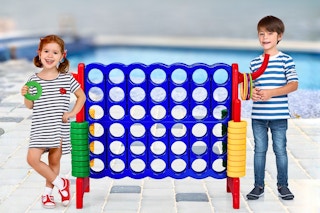 Lifestyle image of 2 kids sanding next to a giant 4-in-a-row game by a pool