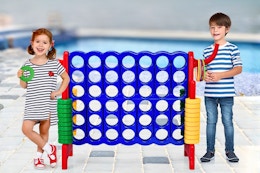 Lifestyle image of 2 kids sanding next to a giant 4-in-a-row game by a pool