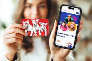 A woman holds up a Target gift card