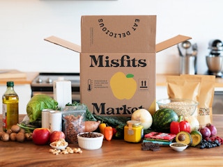 A Misfits Market box on a counter surrounded by food items