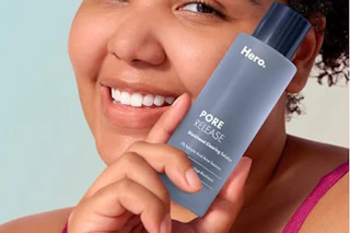 woman holding Hero pore release bottle to face