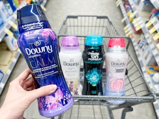 hand holding downy beads in front of shopping cart