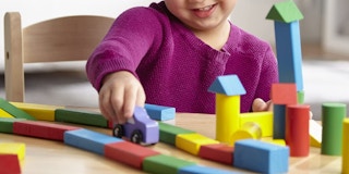 A child playing with a car and blocks