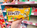 hand holding m&m's chocolate candy in walgreens