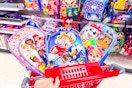 3 character kids backpacks sitting in a target cart in front of backpacks