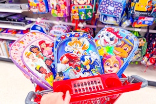 3 character kids backpacks sitting in a target cart in front of backpacks