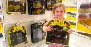Some First Day of School signs stocked at Target with a girl holding one of the signs