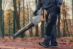 Man using the Keenstone Cordless Leaf Blower on his driveway.