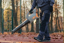 Man using the Keenstone Cordless Leaf Blower on his driveway.