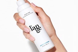 a hand holding a white pump bottle