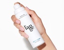 a hand holding a white pump bottle 
