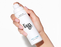 a hand holding a white pump bottle 