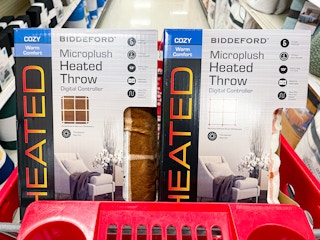 A couple Biddeford Heated throw blankets sitting in a store cart.