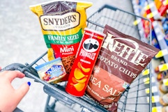 hand pushing shopping cart with snacks