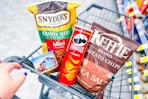 hand pushing shopping cart with snacks