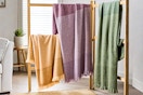 Lifestyle image of the Better Homes & Gardens Throw Blankets (3 colors) draped over wooden ladders 