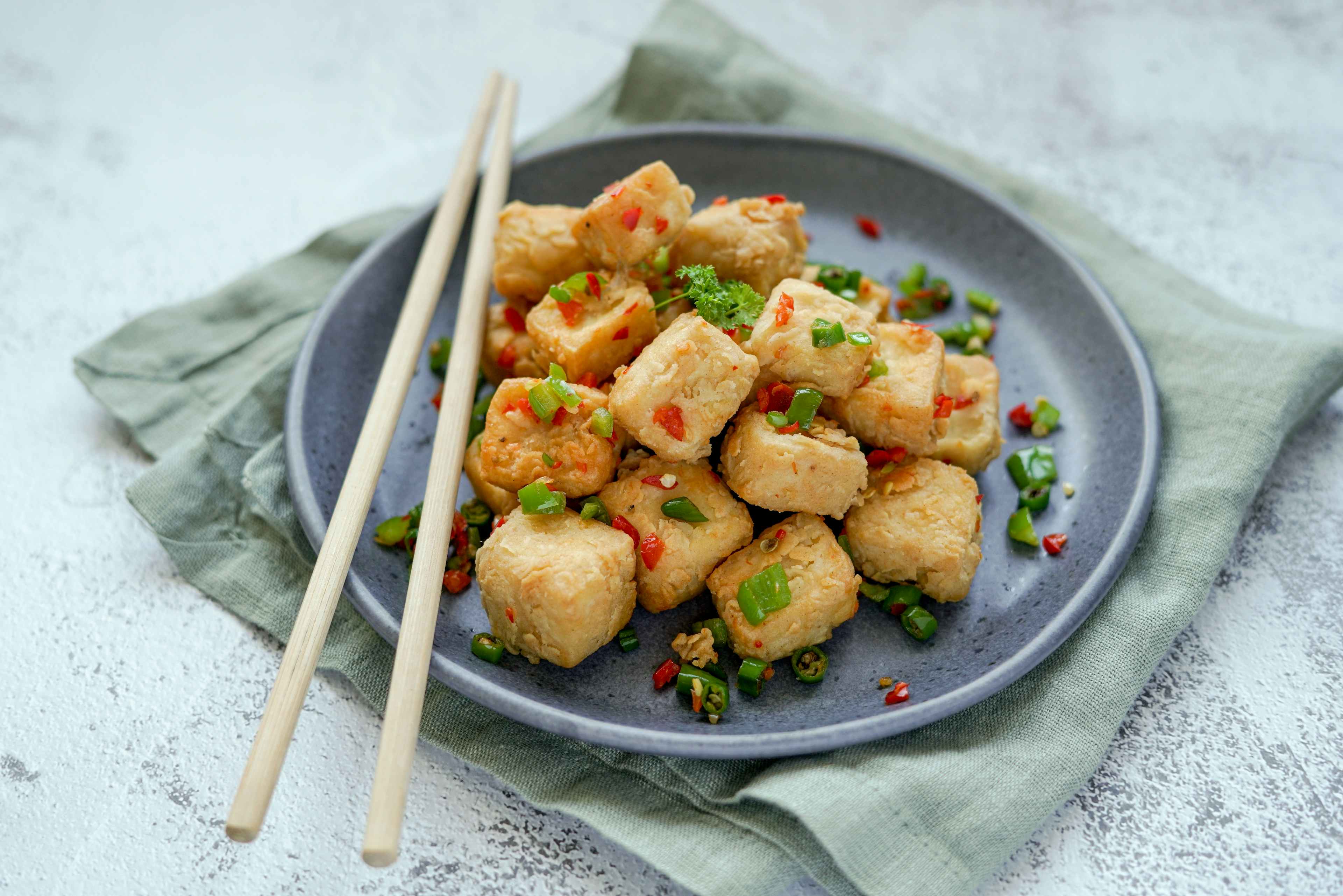crispy tofu bites on a plate with chopsticks