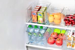 Lifestyle image of clear plastic storage bins used inside fridge to organize grocery items