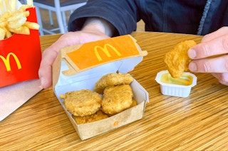 someone sitting in mcdonalds with six-piece chicken mcnuggets, honey mustard, and fries