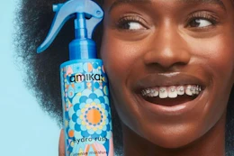 a woman holding amika leave-in conditioner