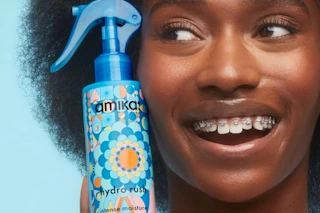 a woman holding amika leave-in conditioner