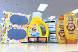 garnier whole blends shampoo, neutrogena wipes, maybelline eyeshadow, tide simply, and honest wipes on a shelf