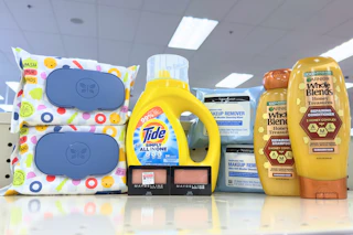 garnier whole blends shampoo, neutrogena wipes, maybelline eyeshadow, tide simply, and honest wipes on a shelf