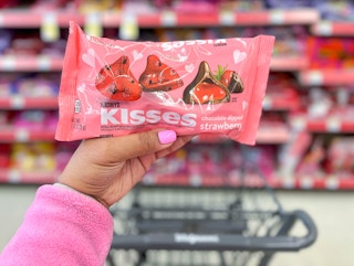 hand holding bag of Hershey's Valentine's day candy bag in front of shopping cart