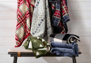 throw blankets hanging on a wall and sitting on a bench