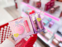 hand holding 2 Target Too Faced gift sets