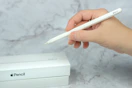 someone holding an apple pencil next to a box