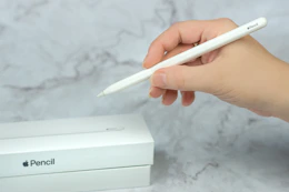 someone holding an apple pencil next to a box