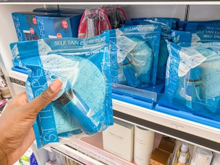 someone holding up a st. tropez self tan express kit