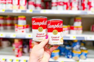 hand holding up two campbell's soups