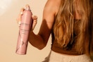 woman holding and spraying Nexxus finishing spray