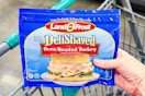 hand holding a pack of land o frost lunch meat