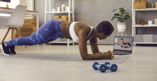 best youtube workout channels - A person watching a workout video and planking