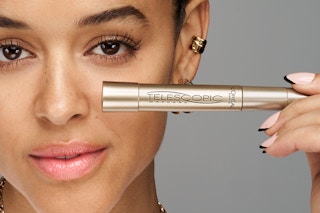 Person holding L'Oreal Paris telescopic mascara to face