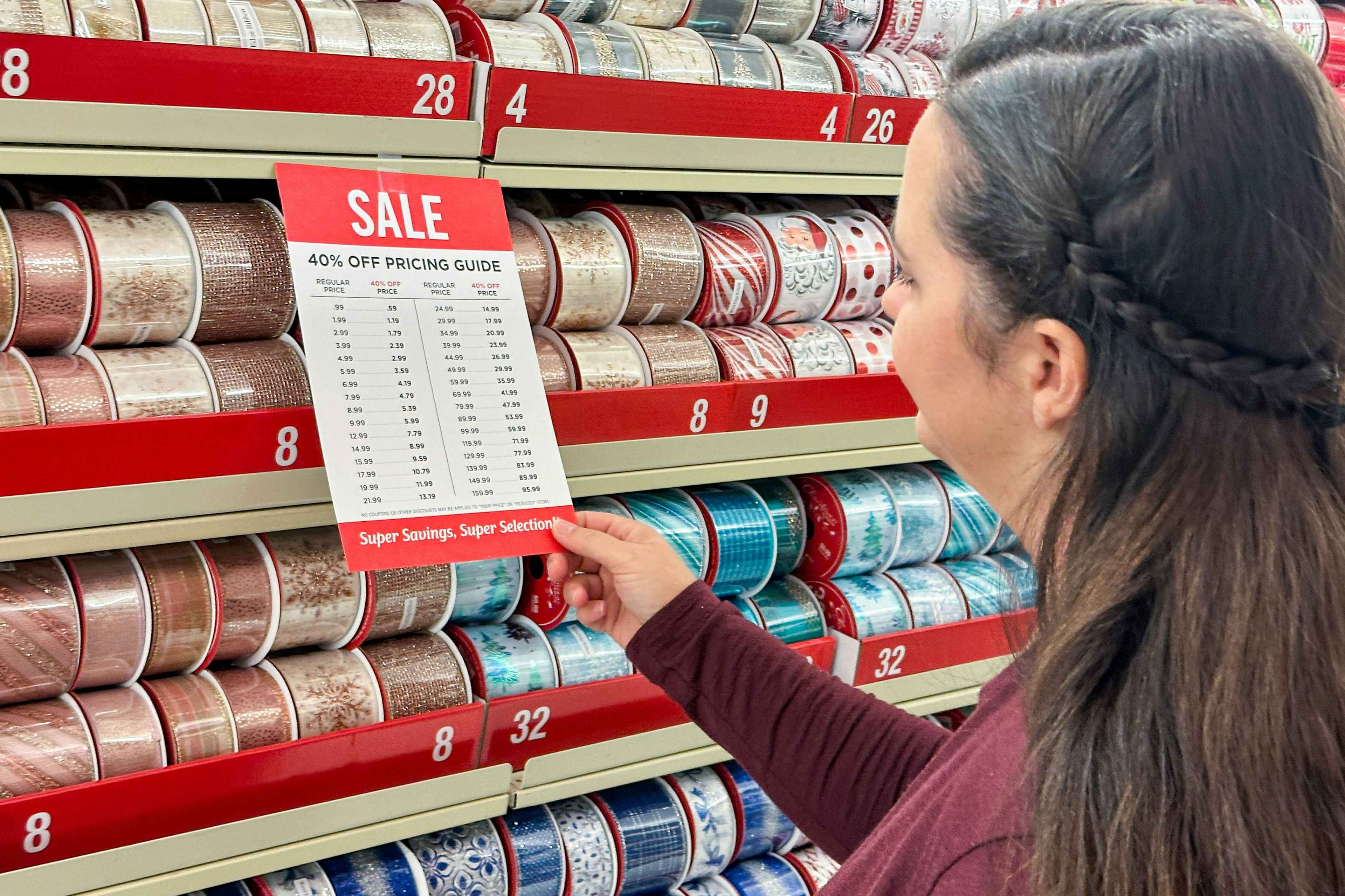 a woman looking at sale pricing in the chrsitmas ribbon section