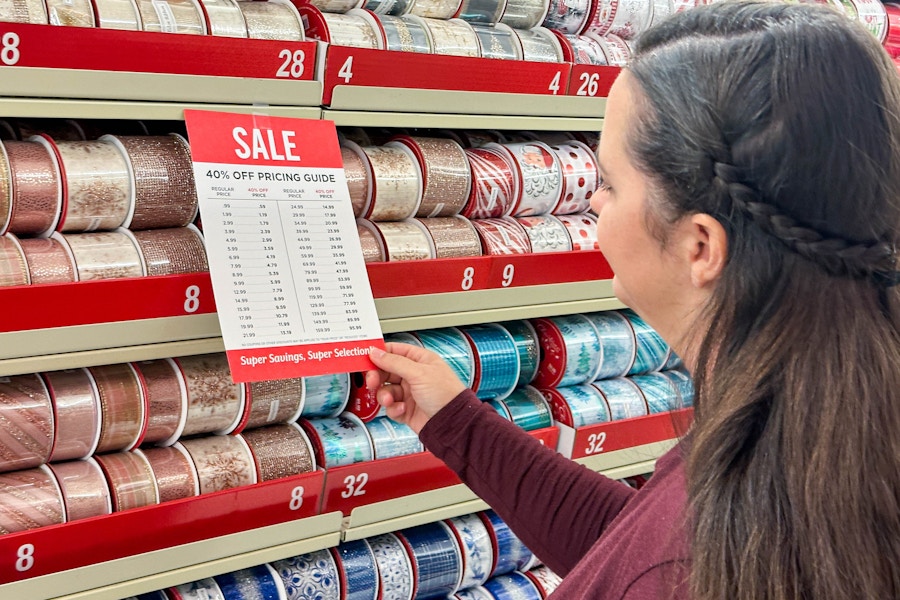 a woman looking at sale pricing in the chrsitmas ribbon section