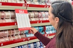 a woman looking at sale pricing in the chrsitmas ribbon section