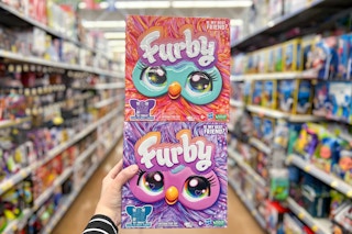 someone holding up furby toys at walmart