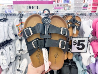 someone holding a pair of birkenstock dupes